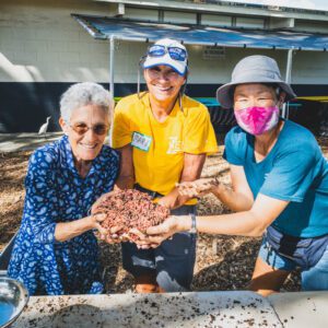 Three ladies holding a ball of composting worms after harvesting vermicast.